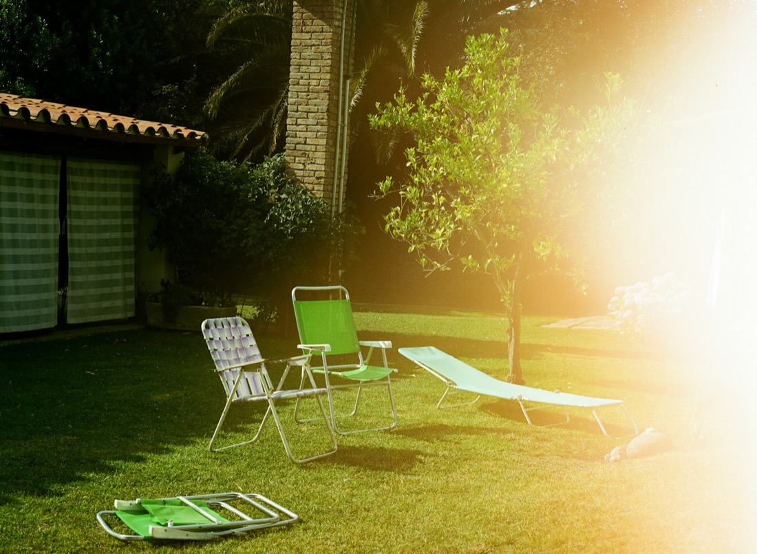 Backyard lawn with deck chairs in afternoon light